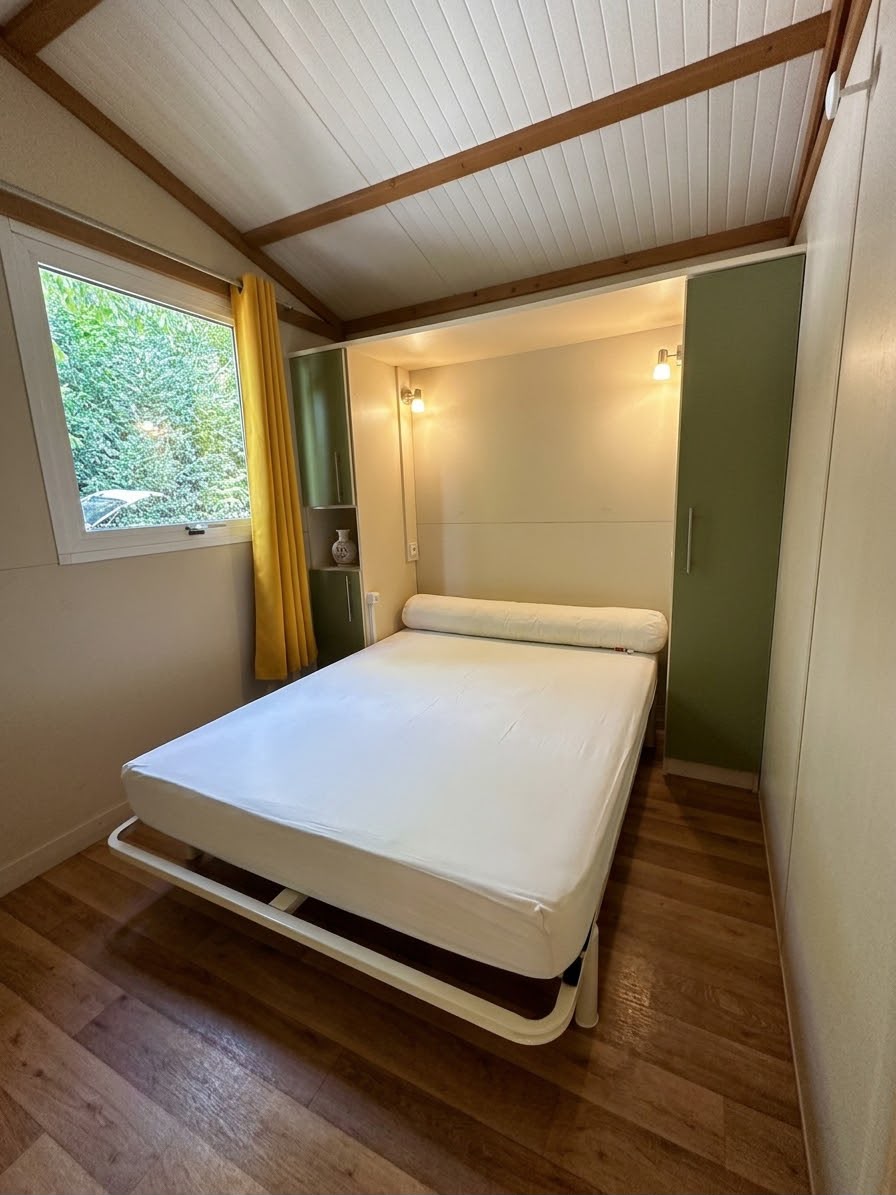 Chambre parentale confortable avec lit double, rangements et vue sur la verdure